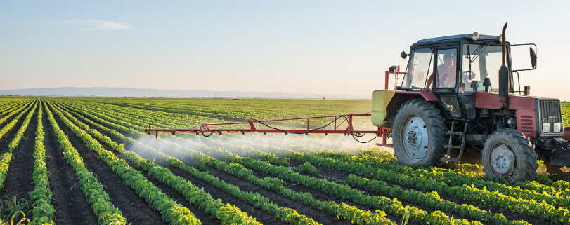 Maquina agrícola pulverizando uma plantação de soja.